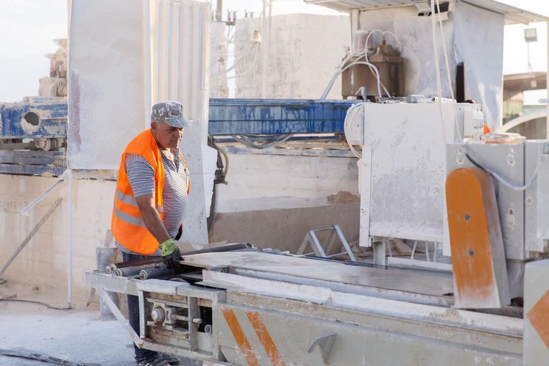Maschinenführer beschickt eine Schneidmaschine mit Travertin