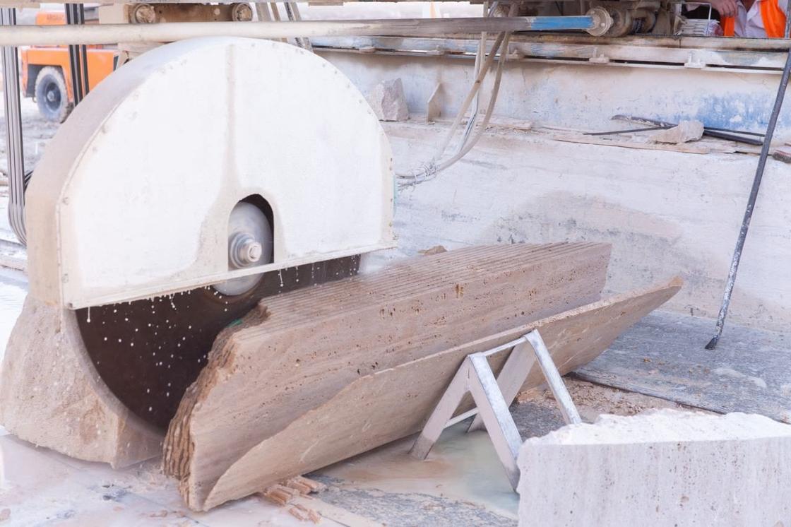 Large disc saw cutting a travertine block into slabs