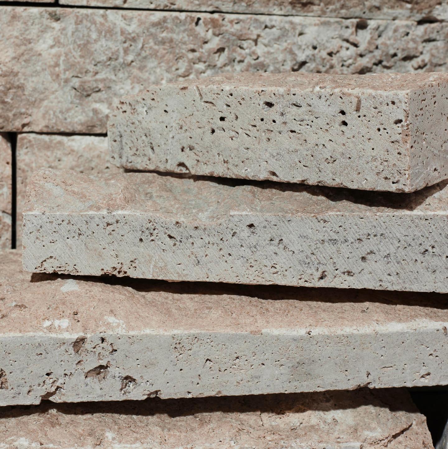 Split-face travertine pieces showing the rough face and sawn beds