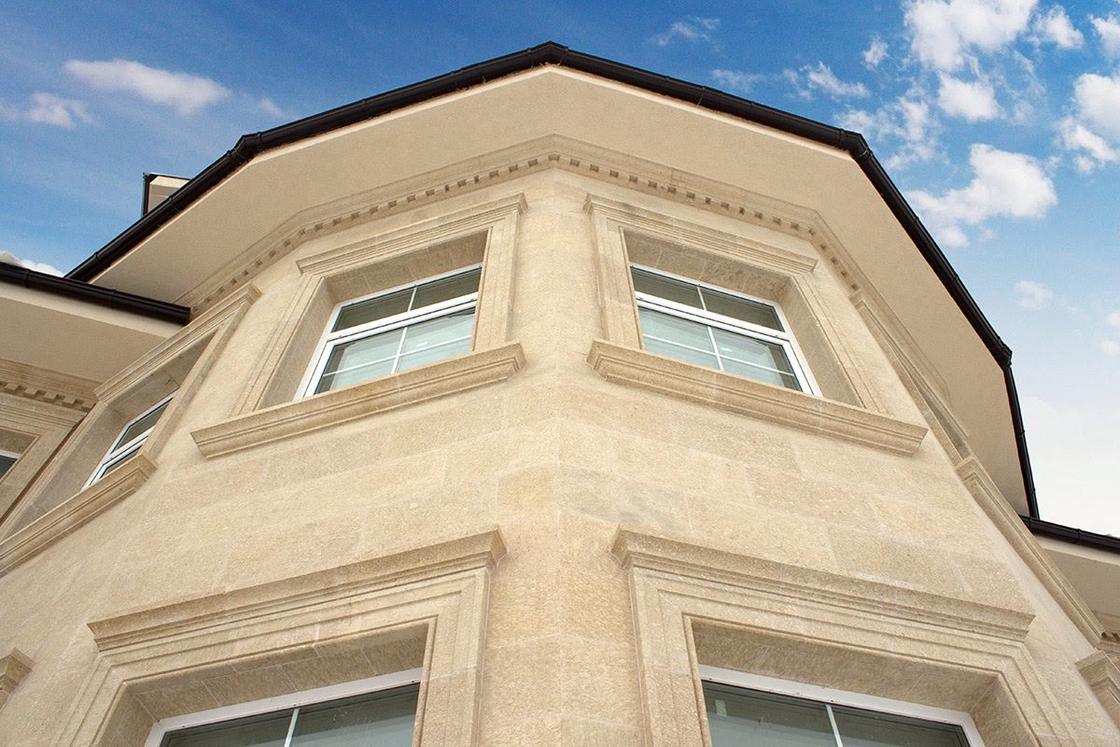 Fenstergewände und Gesimse aus Travertin an einer fertiggestellten Fassade